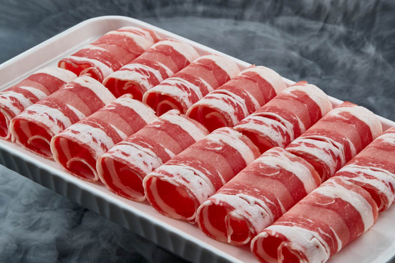 干冰缭绕的背景上摆放的草原肥羊肉卷图片