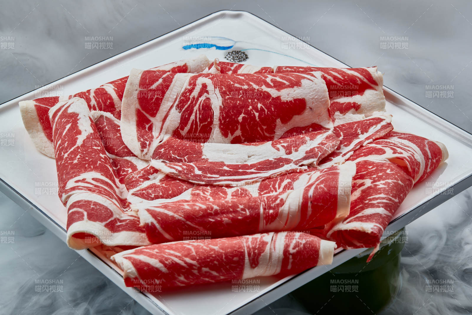 干冰缭绕的背景上摆放的上脑和牛切片图片