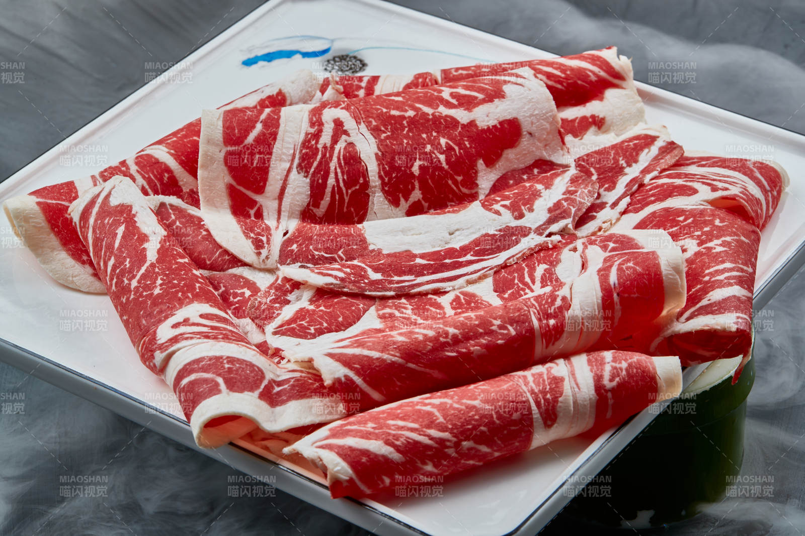 干冰缭绕的背景上摆放的上脑和牛切片图片