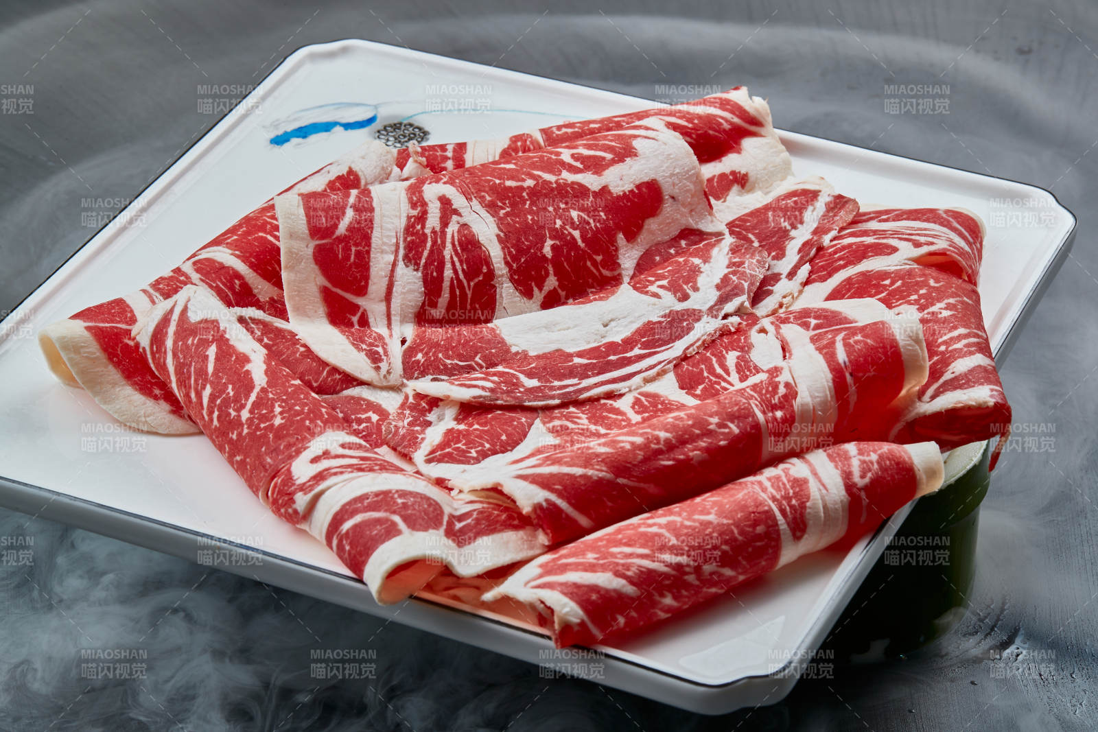 干冰缭绕的背景上摆放的上脑和牛切片图片