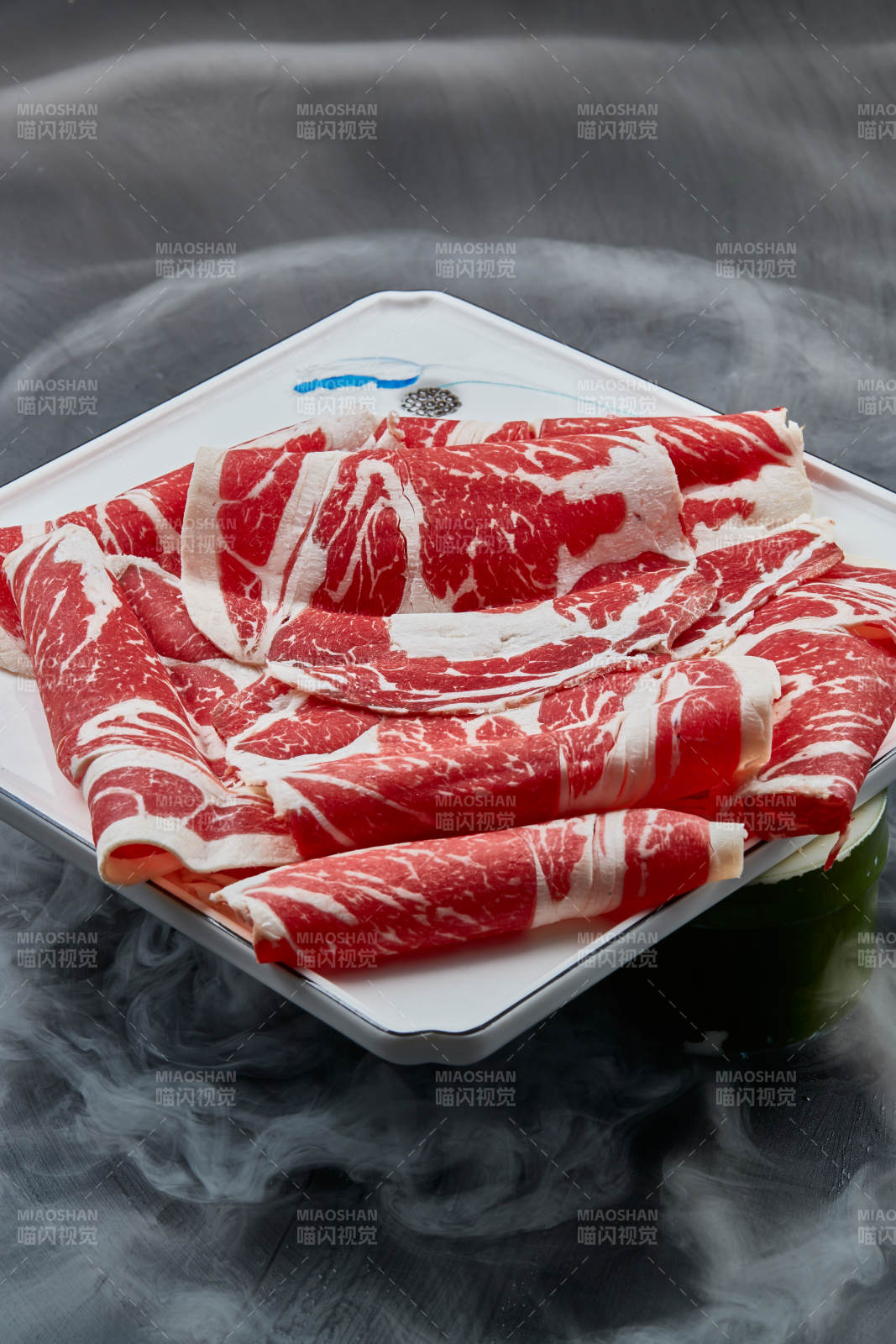 干冰缭绕的背景上摆放的上脑和牛切片图片