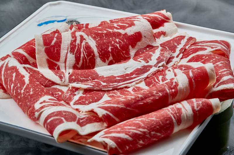 干冰缭绕的背景上摆放的上脑和牛切片图片