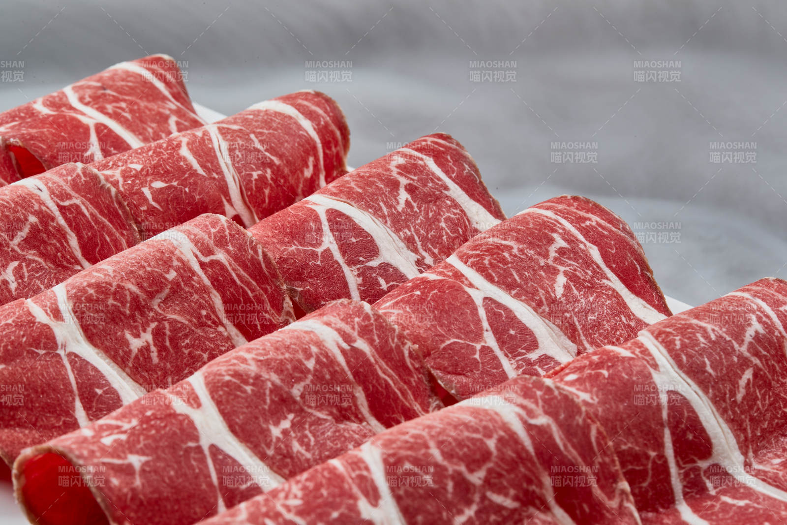 干冰缭绕的背景上摆放的高级雪花肥牛切片图片