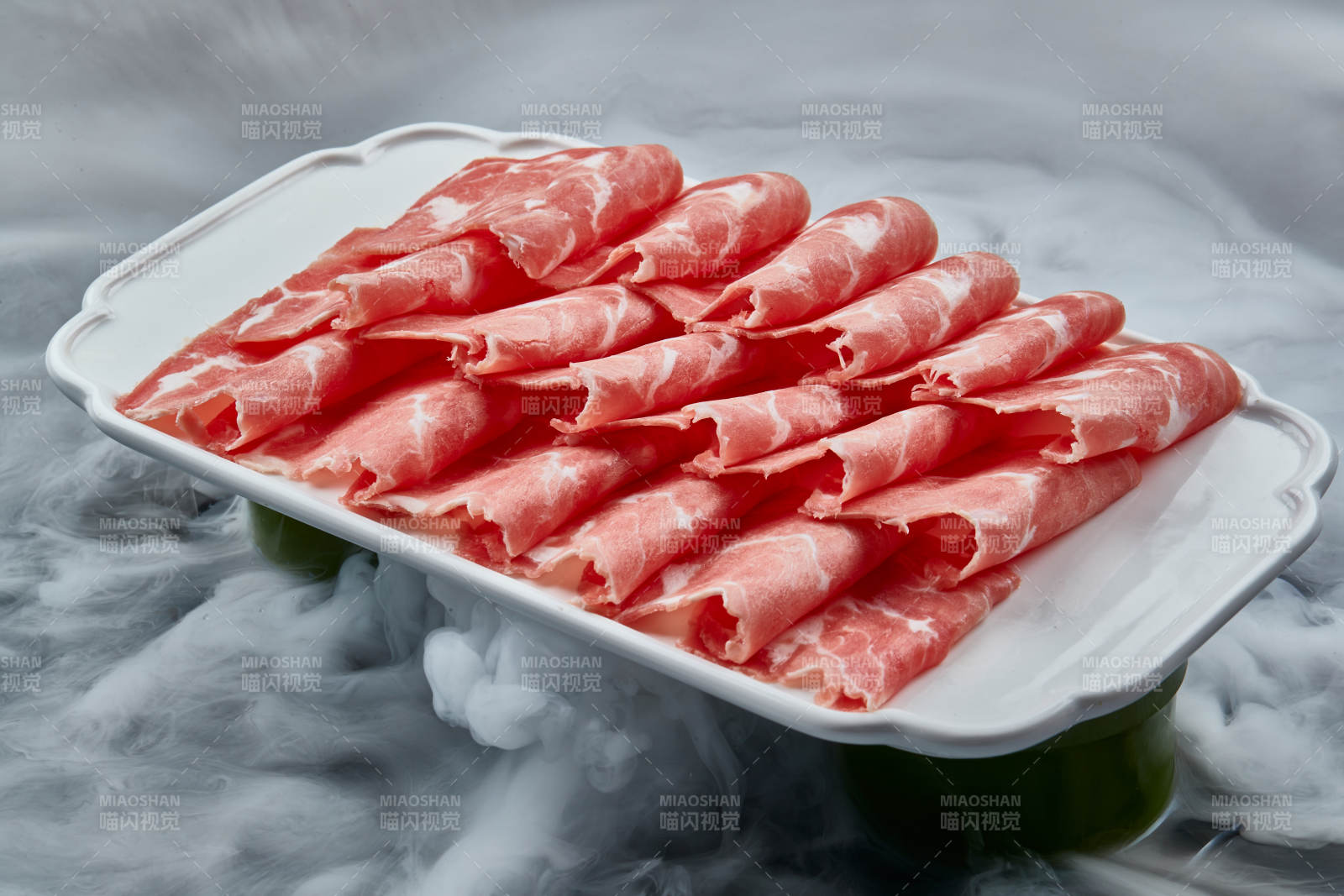 干冰缭绕的背景上摆放的牛肉切片图片