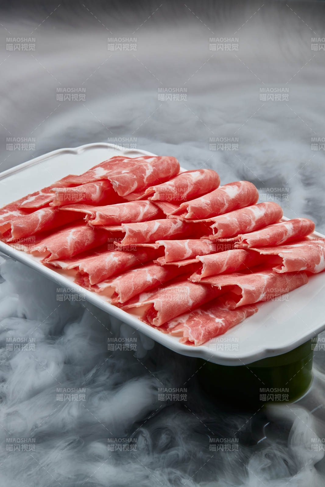 干冰缭绕的背景上摆放的牛肉切片图片