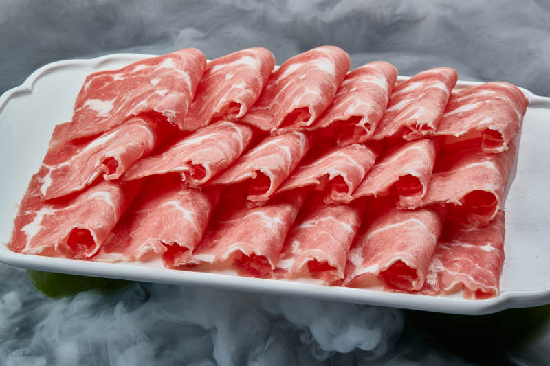 干冰缭绕的背景上摆放的牛肉切片图片