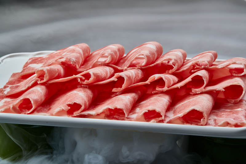 干冰缭绕的背景上摆放的牛肉切片图片