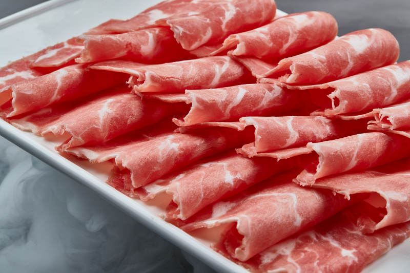 干冰缭绕的背景上摆放的牛肉切片图片