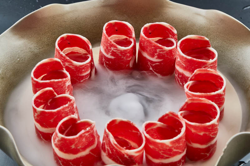 干冰缭绕的背景上摆放的雪花和牛卷图片