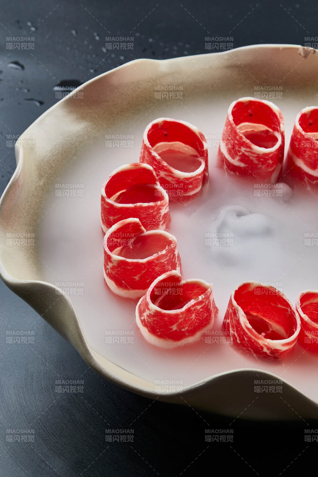 干冰缭绕的背景上摆放的雪花和牛卷图片