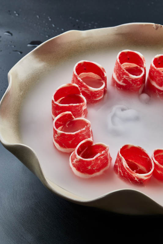 干冰缭绕的背景上摆放的雪花和牛卷图片