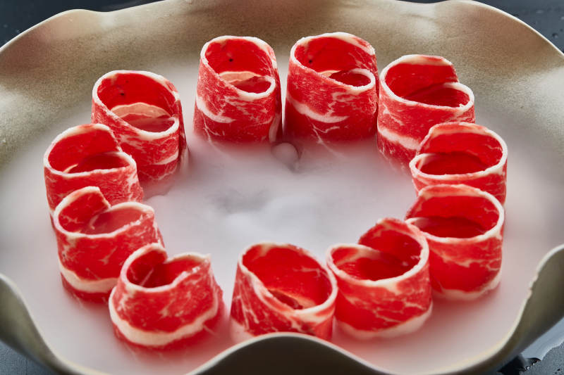 干冰缭绕的背景上摆放的雪花和牛卷图片