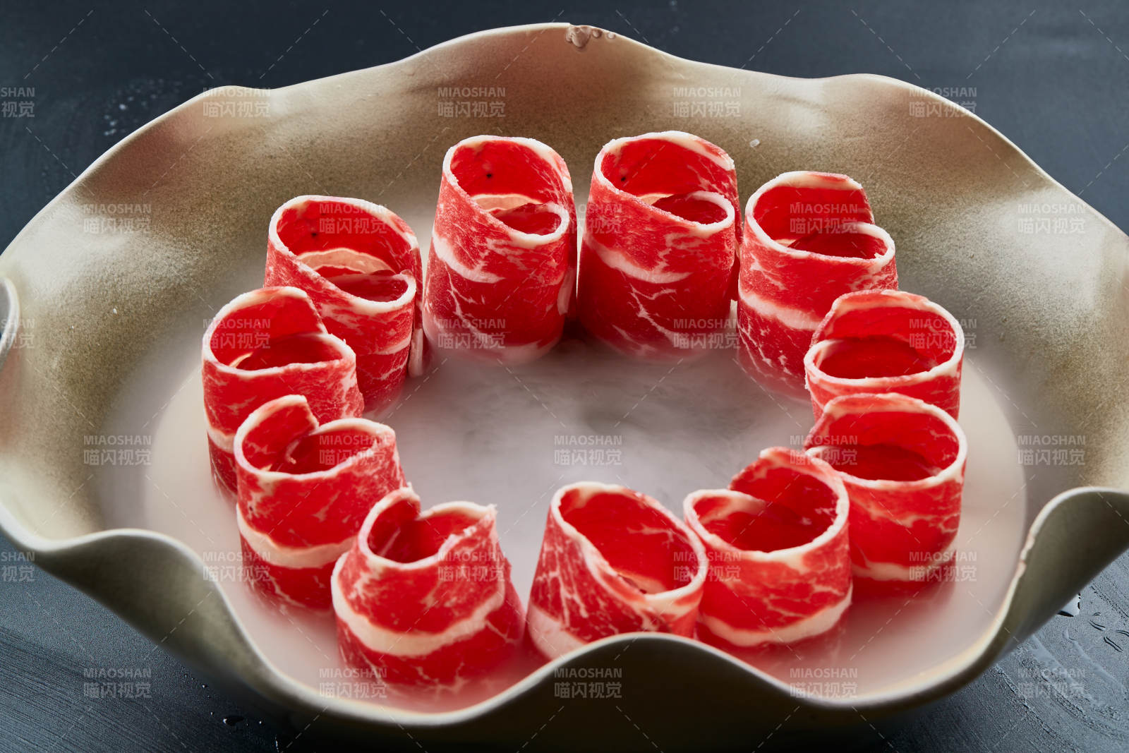 干冰缭绕的背景上摆放的雪花和牛卷图片