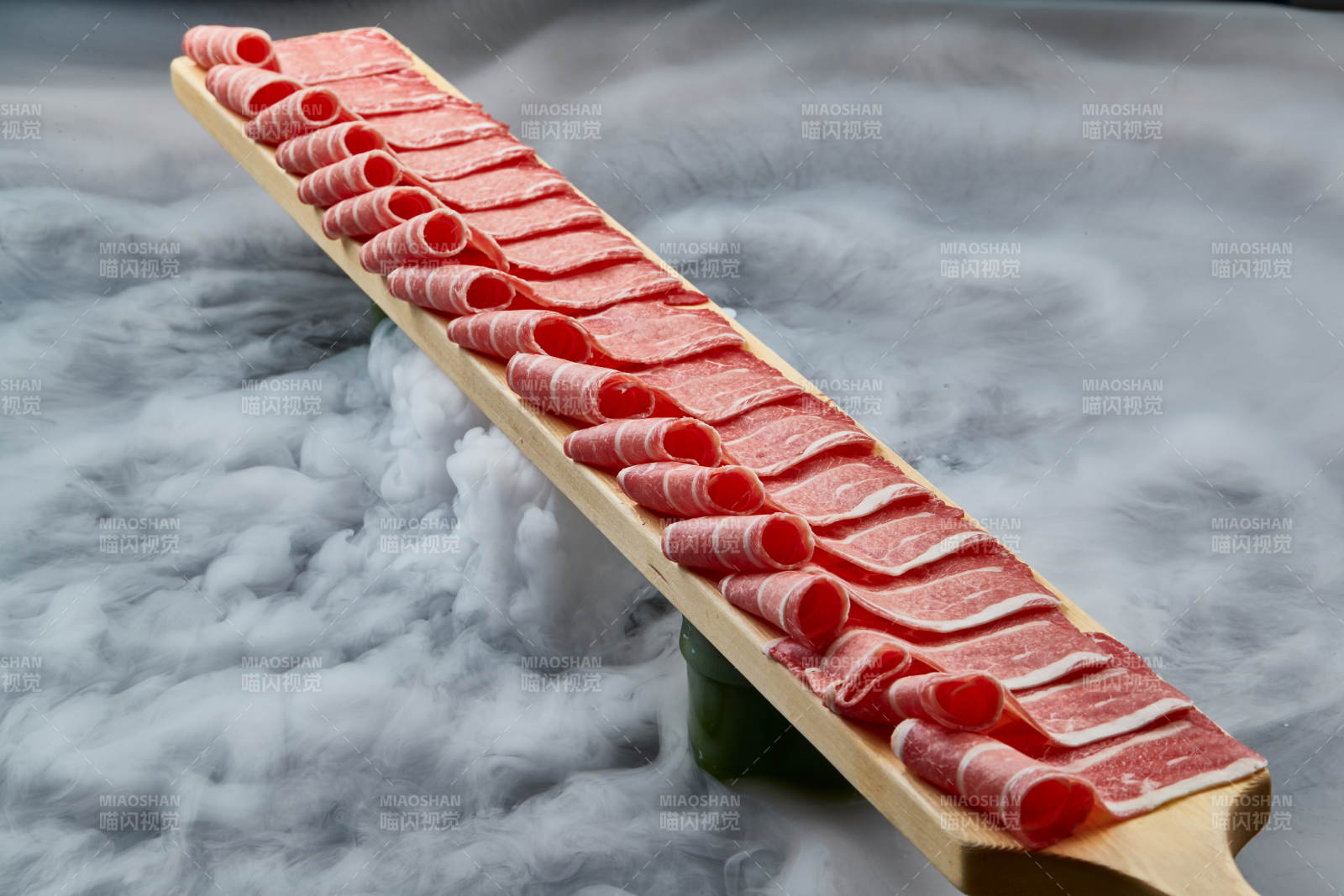 干冰缭绕的背景上摆放的和牛一米肉片图片