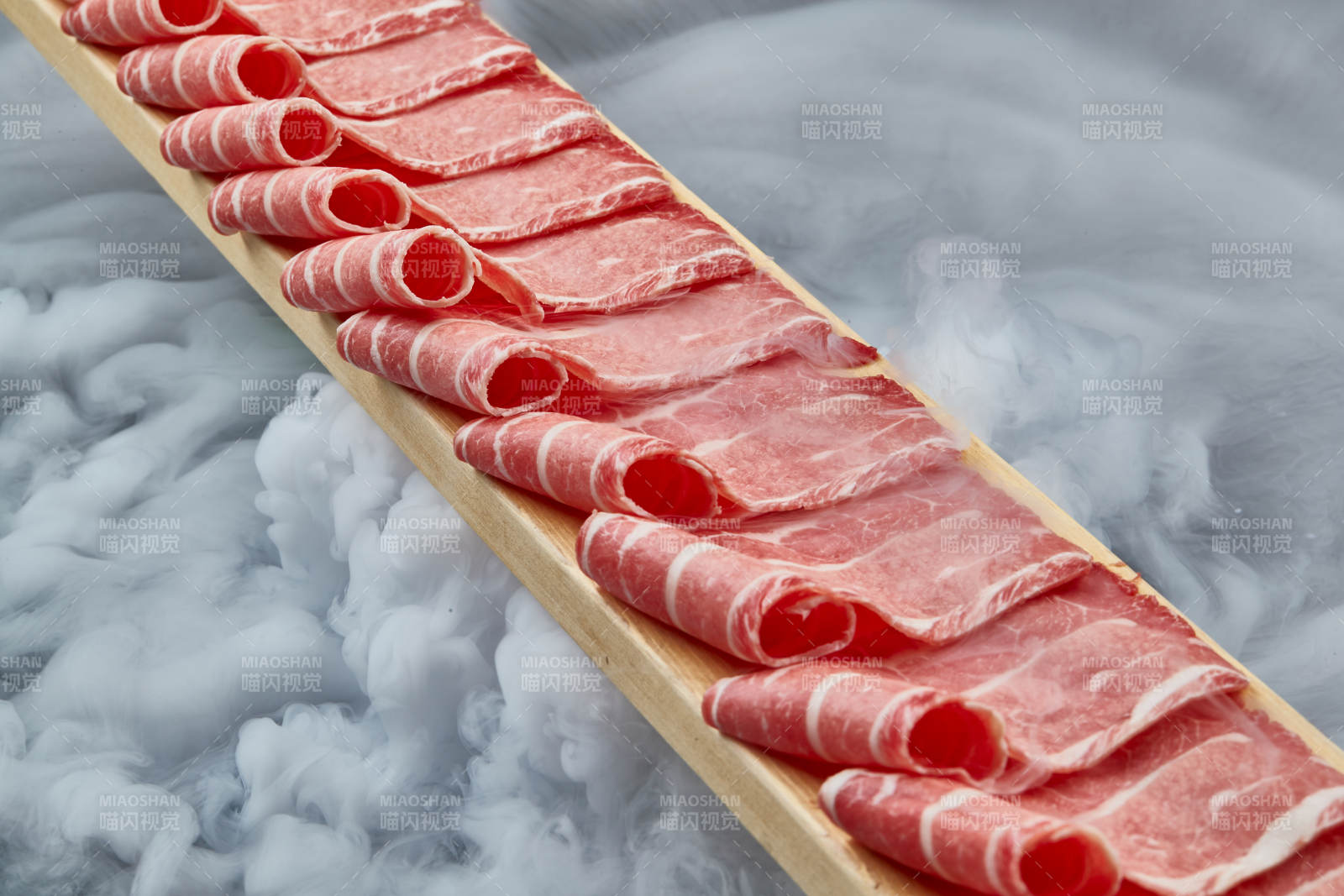 干冰缭绕的背景上摆放的和牛一米肉片图片