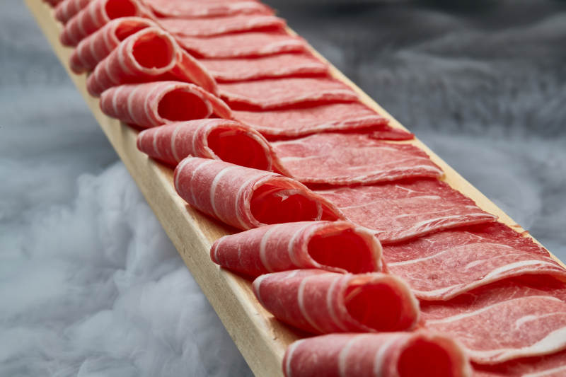 干冰缭绕的背景上摆放的和牛一米肉片图片