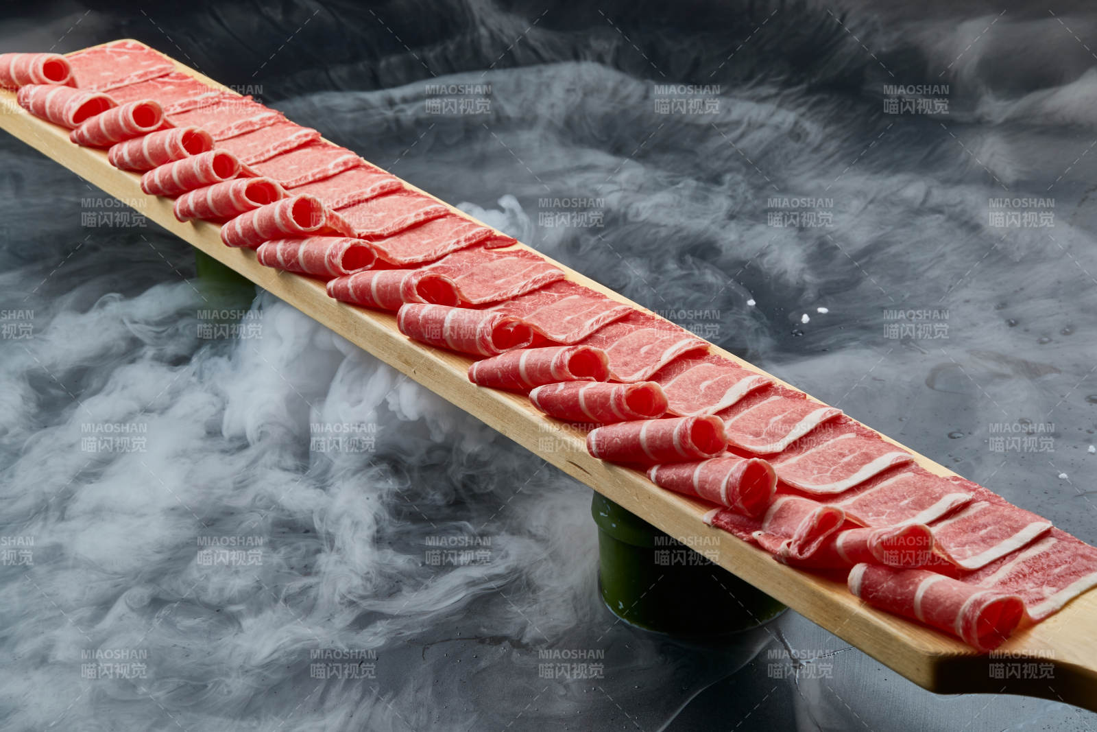 干冰缭绕的背景上摆放的和牛一米肉片图片