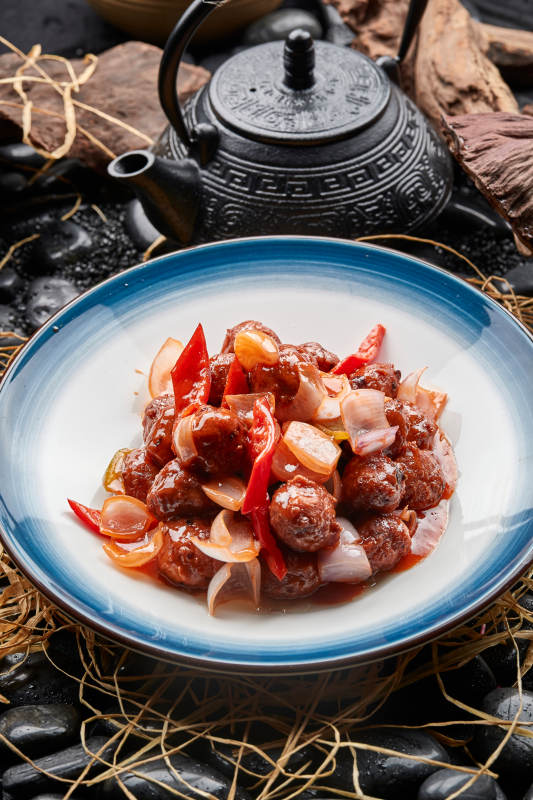 白色瓷盘装的红烧丸子图片