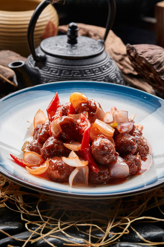 白色瓷盘装的红烧丸子图片