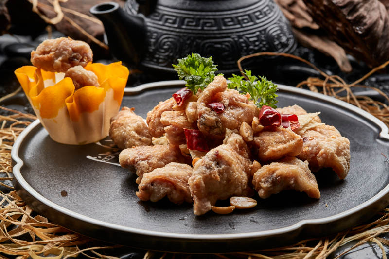 黑色陶餐具装的香炸三黄鸡块图片