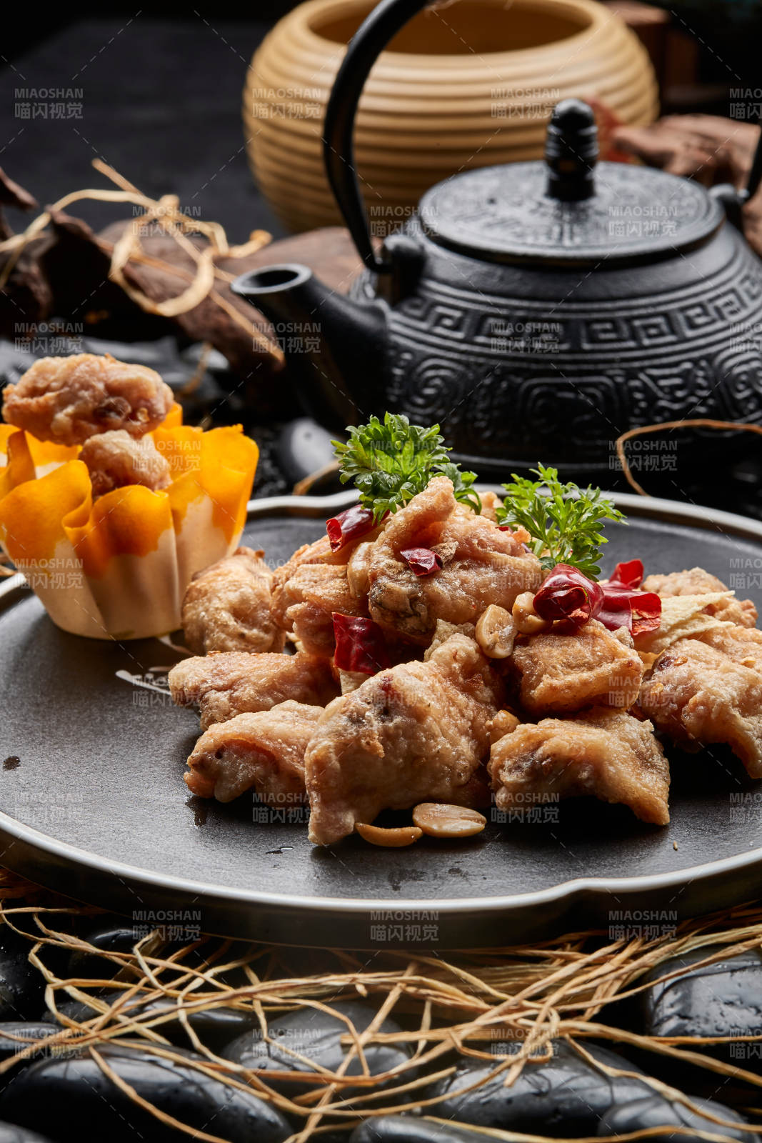 黑色陶餐具装的香炸三黄鸡块图片