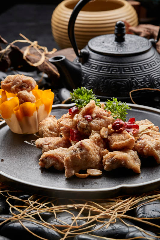 黑色陶餐具装的香炸三黄鸡块图片