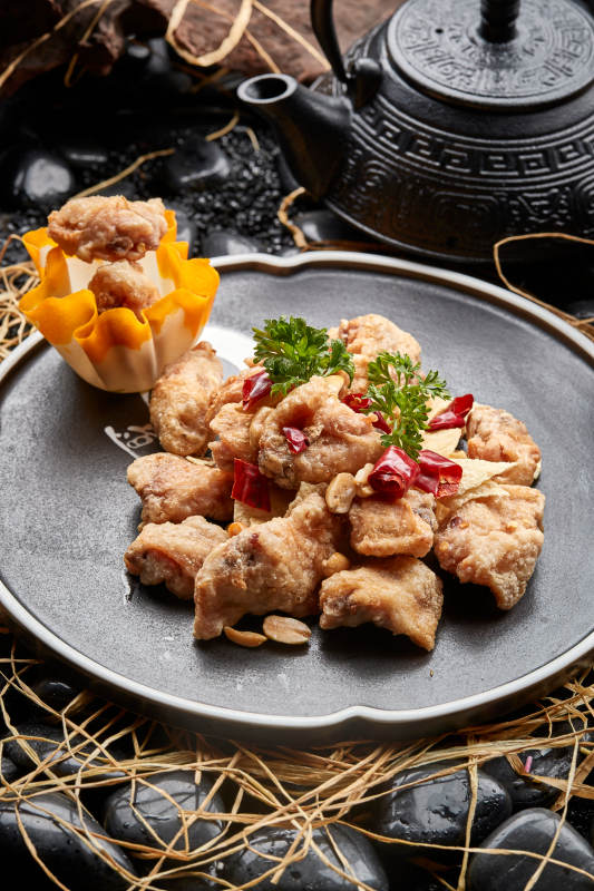 黑色陶餐具装的香炸三黄鸡块图片