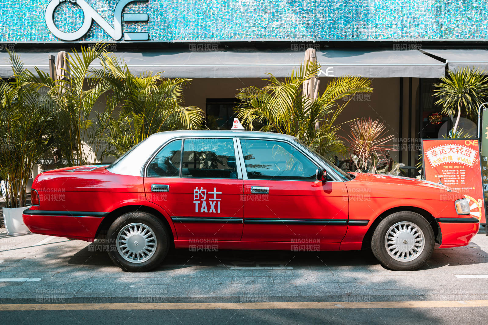 红色出租车停在店前。图片