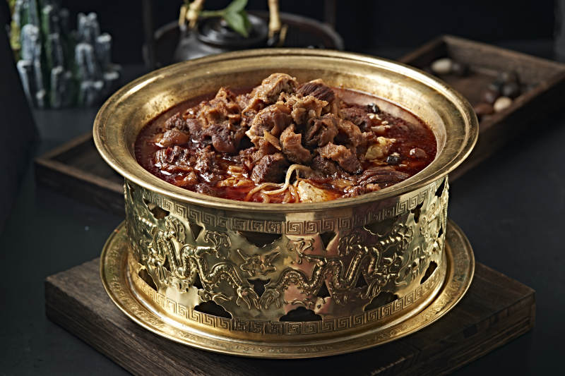 精美铜锅炖煮的红油香辣筋头巴脑图片