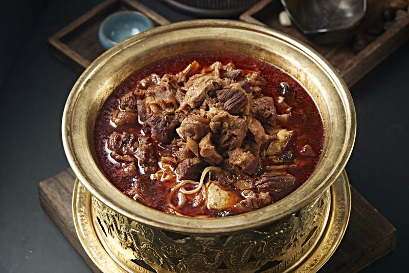 精美铜锅炖煮的红油香辣筋头巴脑图片