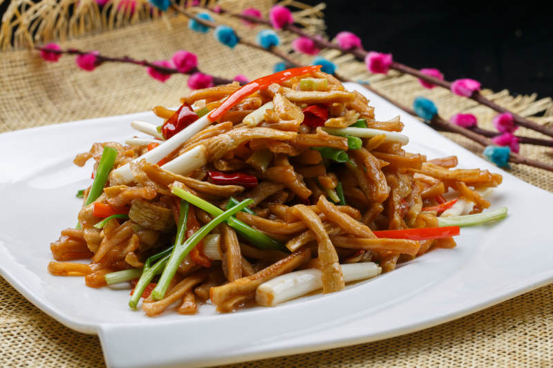 羌爆杏鲍菇摆放在黑色鹅卵石上图片