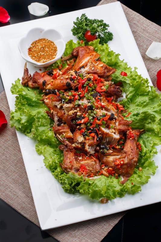 陈旧木板上的方瓷盘装的风味手撕兔图片