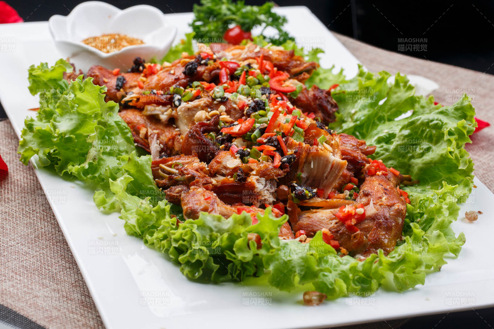 陈旧木板上的方瓷盘装的风味手撕兔图片