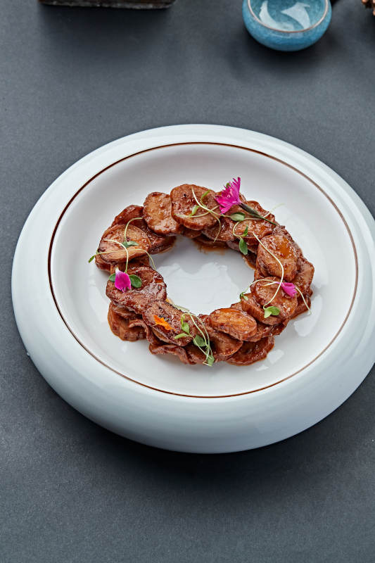 白色瓷盘装的糖腌杏鲍菇片图片