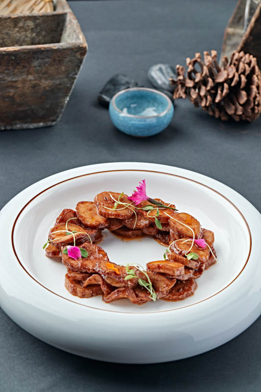 白色瓷盘装的糖腌杏鲍菇片图片