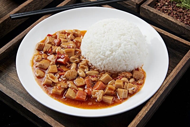 白色瓷盘装的宫保鸡丁盖饭图片