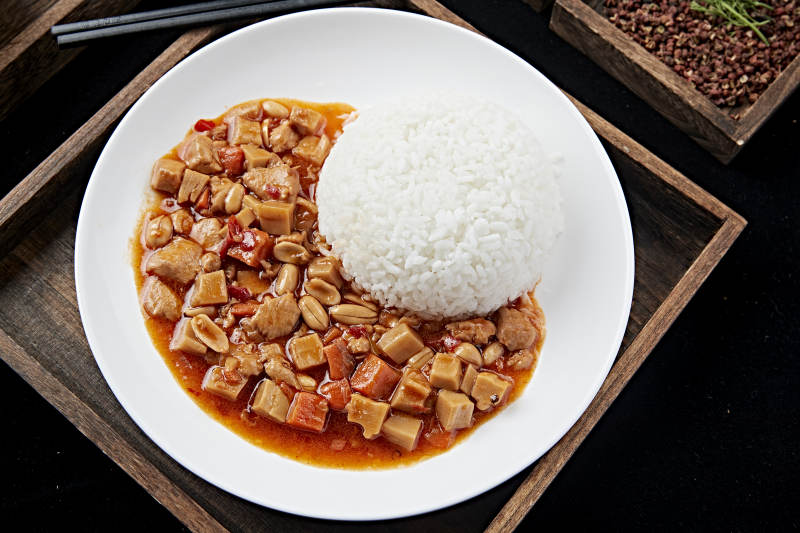 白色瓷盘装的宫保鸡丁盖饭图片