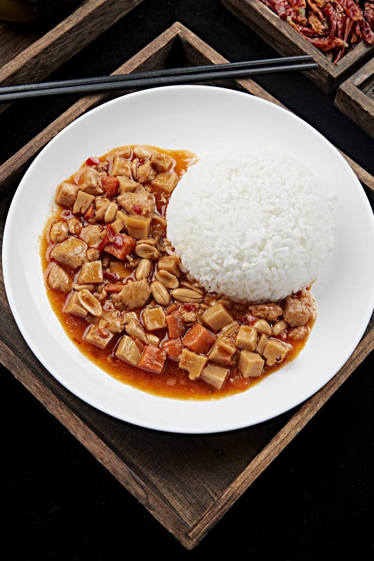 白色瓷盘装的宫保鸡丁盖饭图片