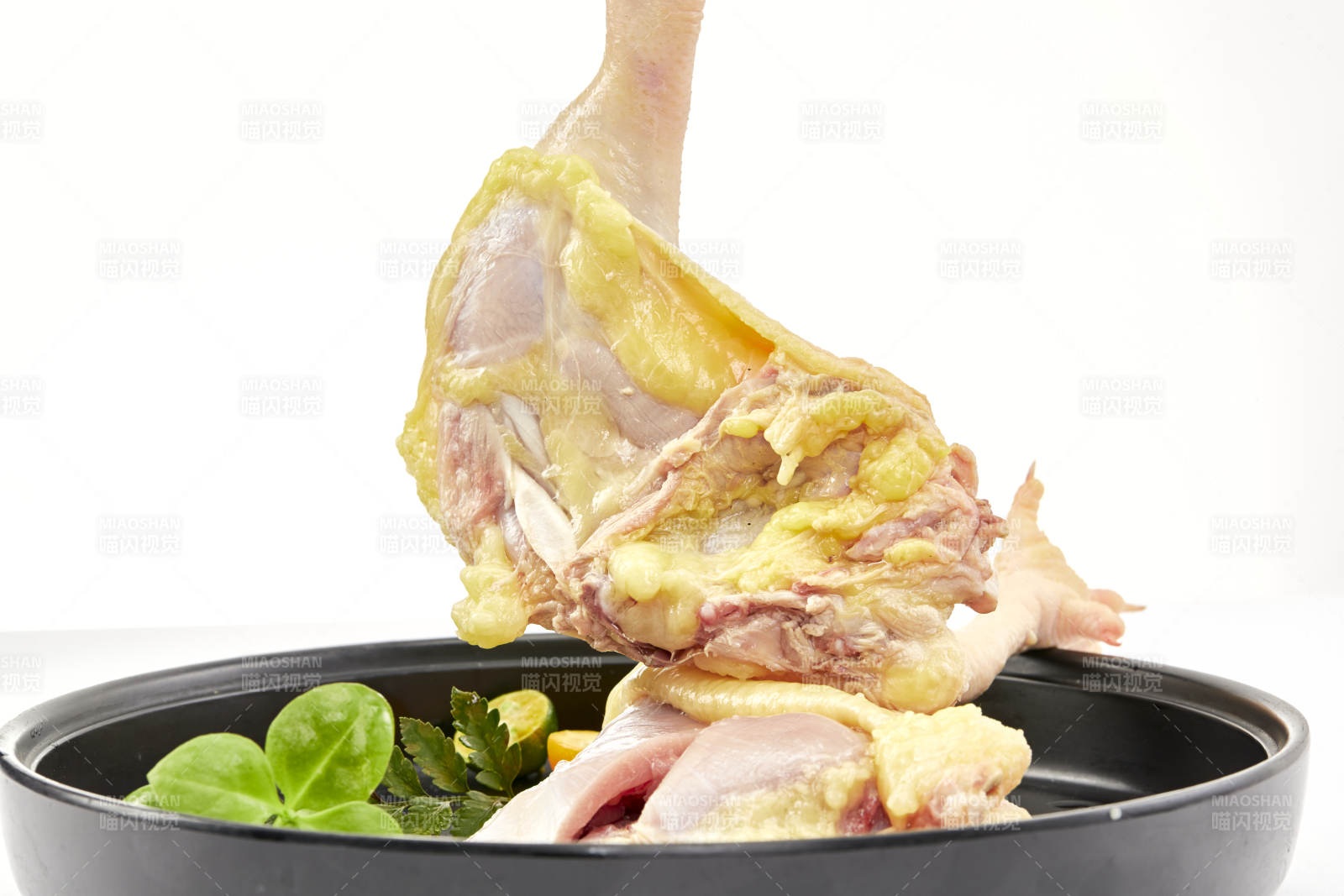 摆放在白色背景上分切好的生鲜鸡腿图片