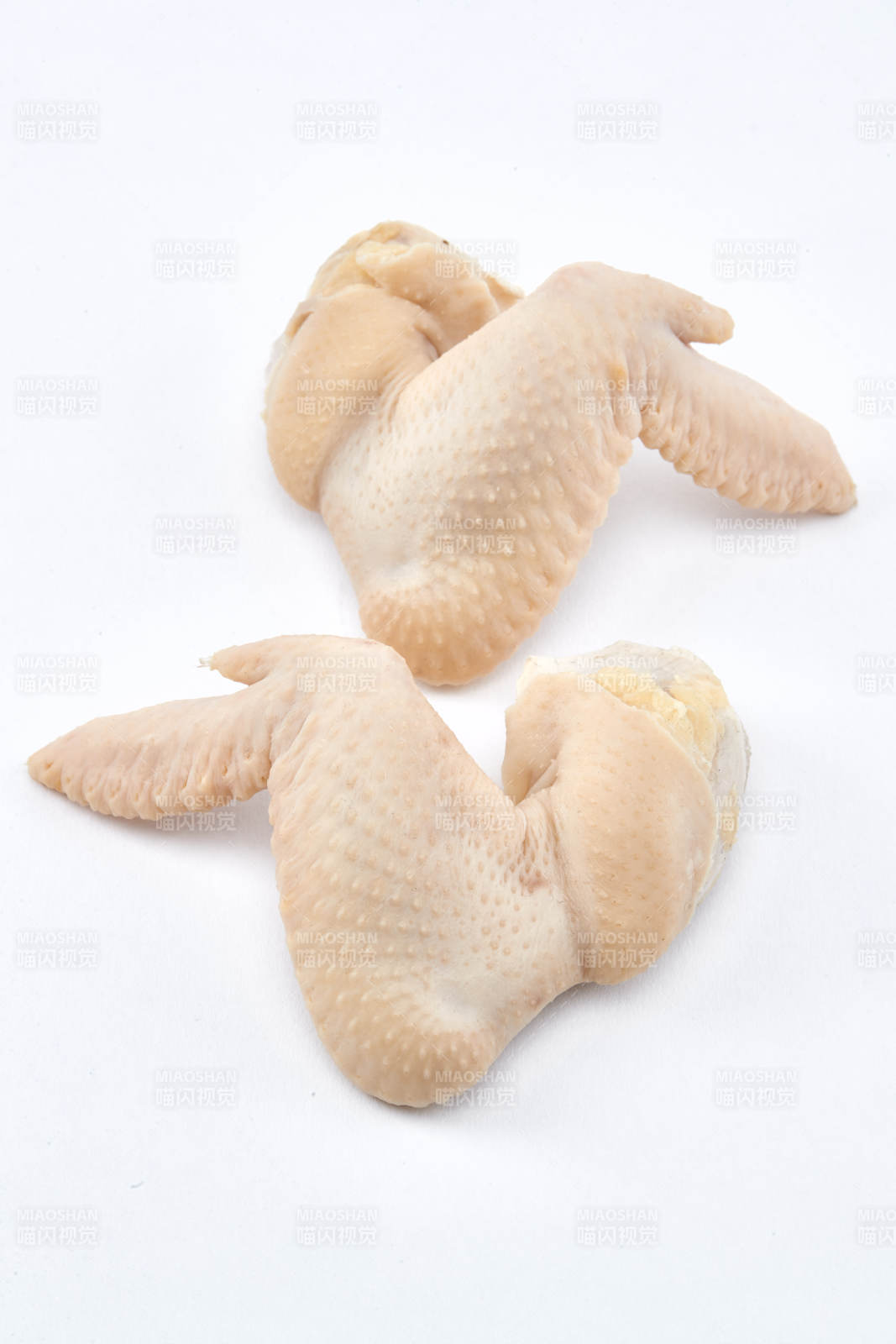 摆放在白色背景上分切好的生鲜鸡腿图片