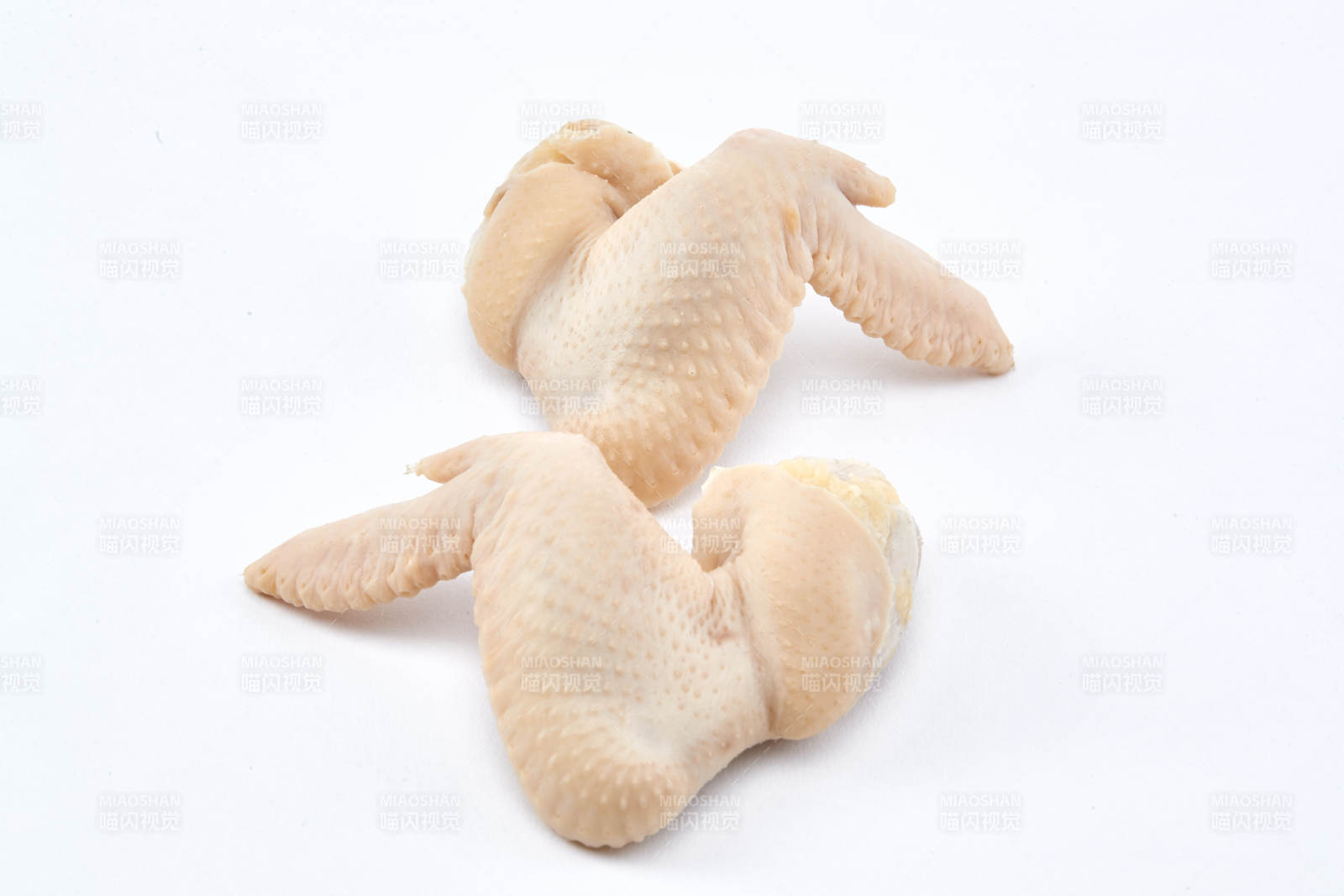 摆放在白色背景上分切好的生鲜鸡腿图片