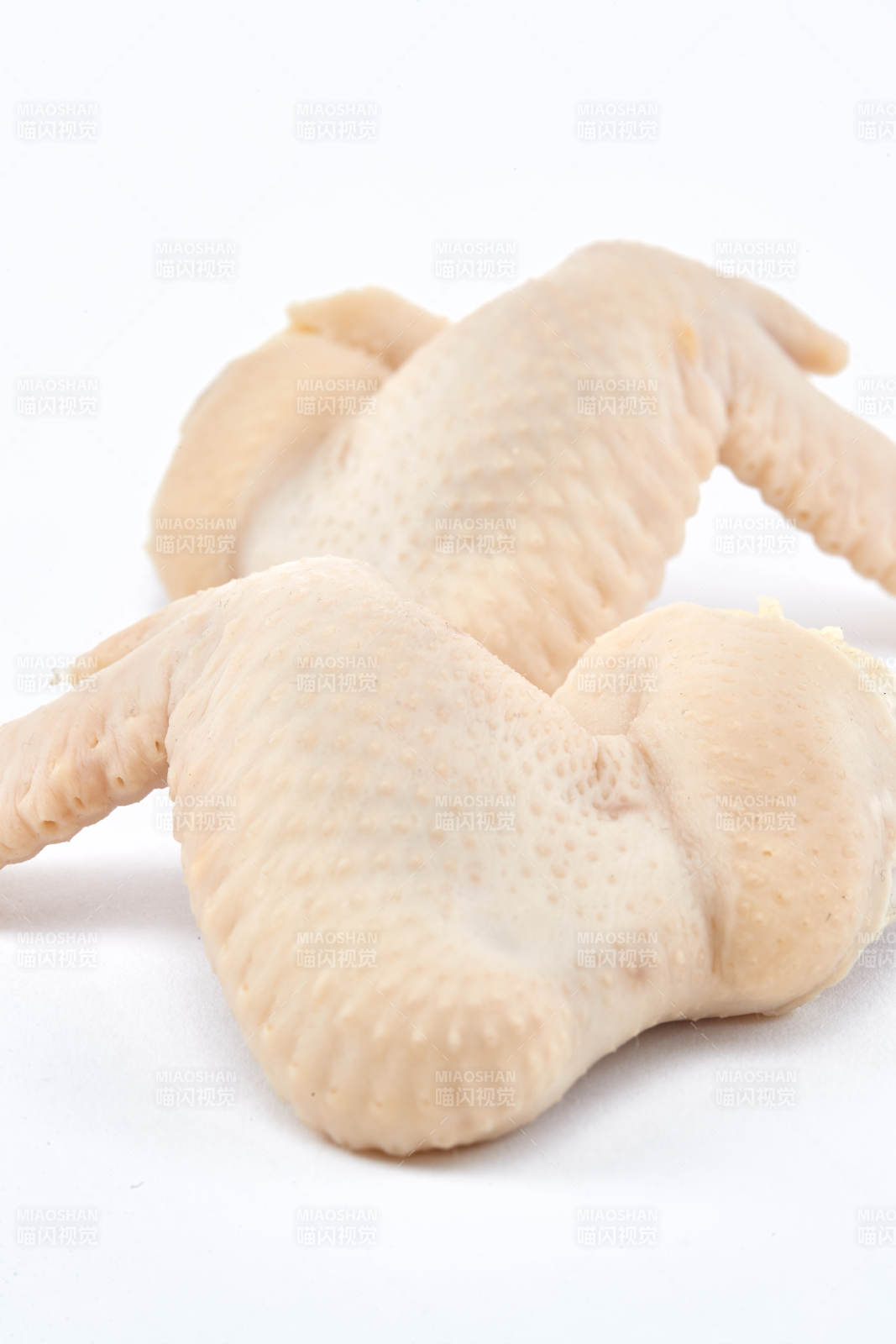 摆放在白色背景上分切好的生鲜鸡腿图片