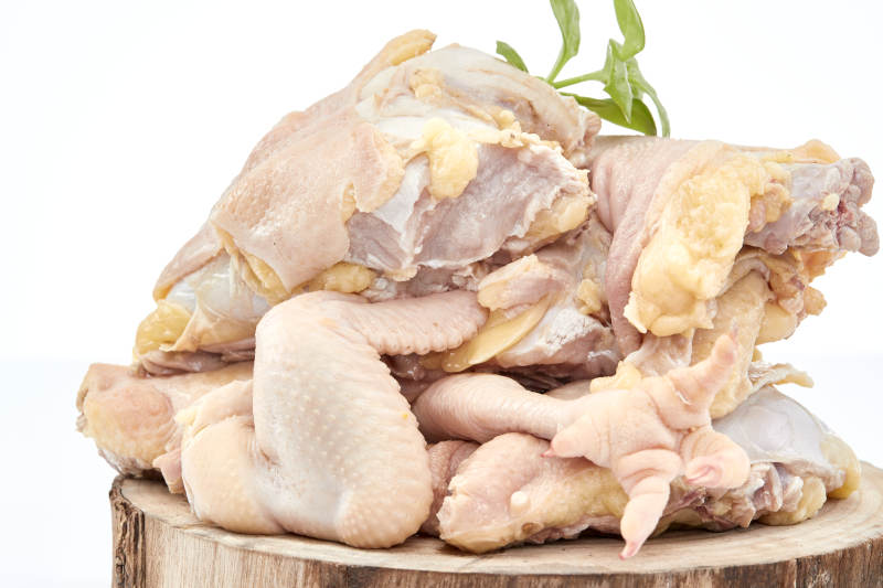 摆放在白色背景上分切好的生鲜鸡腿图片