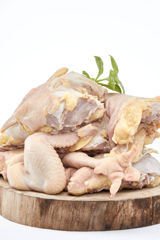 摆放在白色背景上分切好的生鲜鸡腿图片