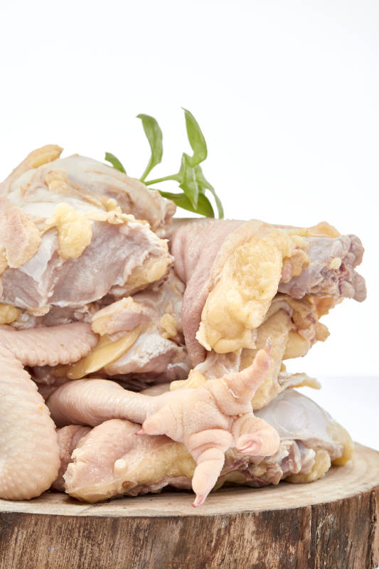 摆放在白色背景上分切好的生鲜鸡腿图片
