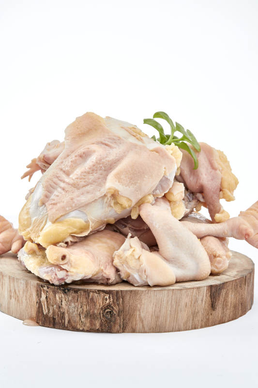 摆放在白色背景上分切好的生鲜鸡腿图片