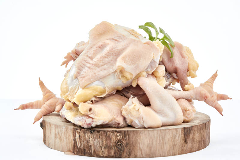 摆放在白色背景上分切好的生鲜鸡腿图片