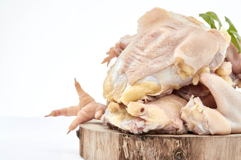 摆放在白色背景上分切好的生鲜鸡腿图片