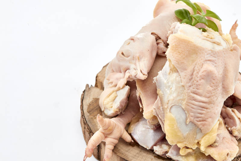 摆放在白色背景上分切好的生鲜鸡腿图片