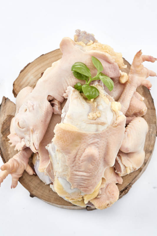 摆放在白色背景上分切好的生鲜鸡腿图片